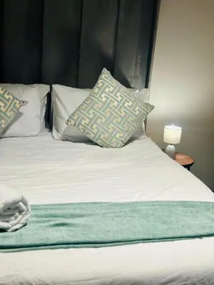 a bed with two pillows on top of it at Modern Retreat in Waterfall Midrand with Pool & Restaurant in Kyalami