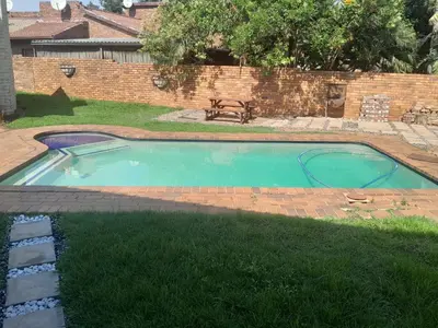 a small swimming pool in a yard with a bench at Transit Haven - 2 Bed Retreat in Kempton Park