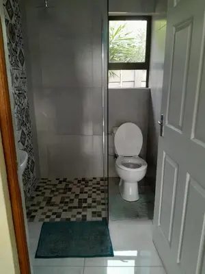 a small bathroom with a toilet and a window at Transit Haven - 2 Bed Retreat in Kempton Park