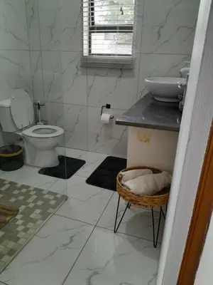 a white bathroom with a toilet and a sink at Transit Haven - 2 Bed Retreat in Kempton Park