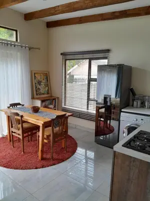 a kitchen with a wooden table with chairs and a refrigerator at Transit Haven - 2 Bed Retreat in Kempton Park