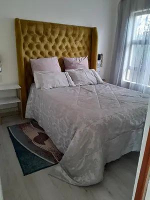 a bedroom with a large bed with a large headboard at Transit Haven - 2 Bed Retreat in Kempton Park