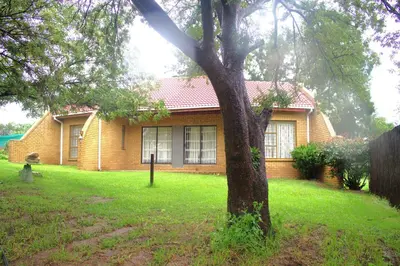a house with a tree in front of it at Ador Lodges in Midrand