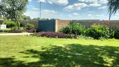 a garden with a green lawn and some flowers at Ador Lodges in Midrand