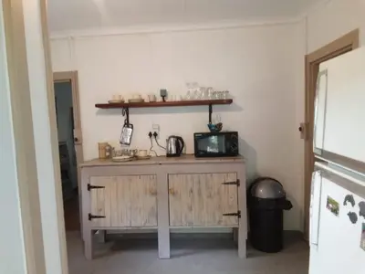 a kitchen with a wooden cabinet and a microwave at Church Mouse House in Pilgrimʼs Rest