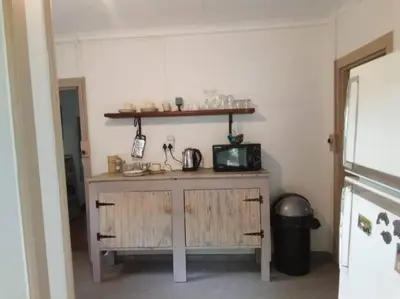 a kitchen with a counter with a microwave and a shelf at Church Mouse House in Pilgrimʼs Rest