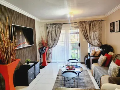 a living room with a couch and a table at Olympia in Pretoria