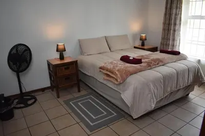a bedroom with a bed with two pillows on it at 39 on Clarendon in Graskop