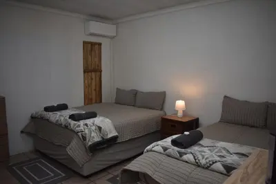 a bedroom with two beds and a table with a lamp at 39 on Clarendon in Graskop