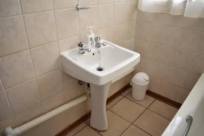 a bathroom with a white sink and a toilet at 39 on Clarendon in Graskop
