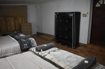 a living room with two beds and a dresser at 39 on Clarendon in Graskop