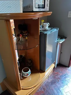 a kitchen shelf with a microwave and a refrigerator at Garden Studio in Waterkloof Ridge in Pretoria