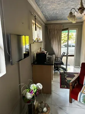 a living room with a tv on the wall at Garden Studio in Waterkloof Ridge in Pretoria