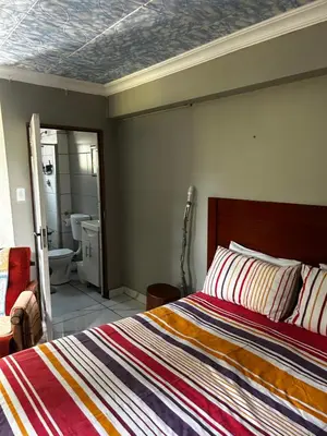 a bedroom with a bed and a bathroom at Garden Studio in Waterkloof Ridge in Pretoria