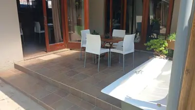 a patio with a table and chairs on a porch at 329 on 30th Avenue Villieria Juane in Pretoria