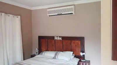 a bed with a wooden headboard in a bedroom at 329 on 30th Avenue Villieria Juane in Pretoria