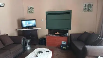 a living room with two couches and a flat screen tv at 329 on 30th Avenue Villieria Juane in Pretoria