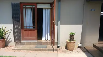 a door of a house with two potted plants in front at 329 on 30th Avenue Villieria Juane in Pretoria
