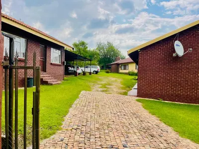 a brick walkway next to a brick building at KINGs' PALACE GUESTHOUSE in Ermelo