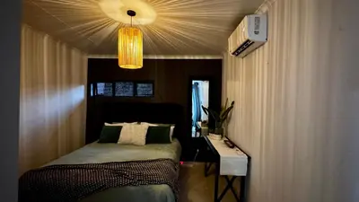 a bedroom with a bed and a table and a light at Micro Urban Oasis 1 in Pretoria