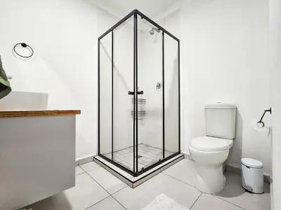 a bathroom with a glass shower and a toilet at Micro Urban Oasis 1 in Pretoria