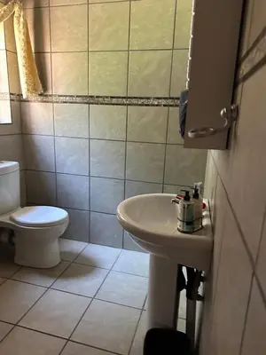 a bathroom with a toilet and a sink at Okgethilwe Lodge in Sabie