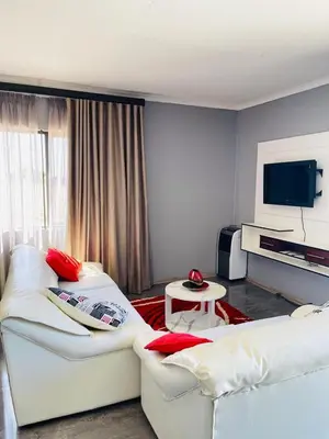 a living room with two white couches and a television at Mercy House Lodge in Northam