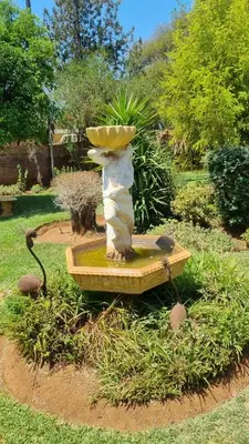 a statue of a birdbath in a garden at Mercy House Lodge in Northam