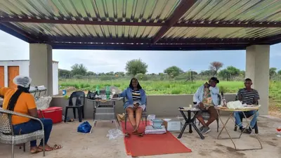a group of people sitting at tables under a pergola at Mercy House Lodge in Northam