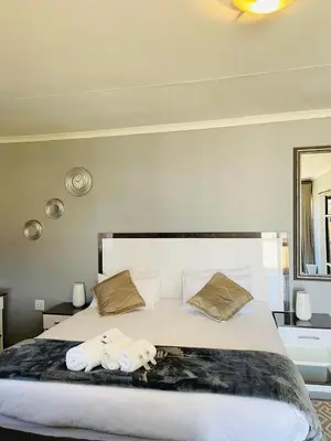 a bedroom with a large bed with towels on it at Mercy House Lodge in Northam
