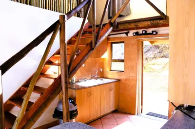 a bathroom with a sink and a wooden staircase at Meerrus Self-Catering Home in Lake Chrissie