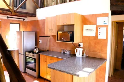 a kitchen with wooden cabinets and a stainless steel refrigerator at Meerrus Self-Catering Home in Lake Chrissie