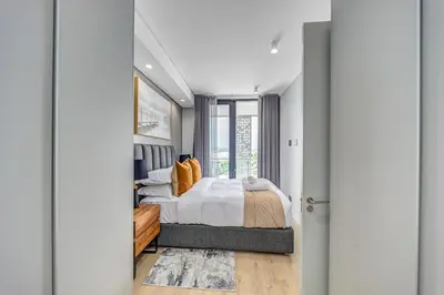 a bedroom with a bed and a large window at Lumina on 8th in Midrand