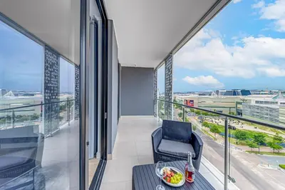 a balcony with a chair and a bowl of fruit on a table at Lumina on 8th in Midrand