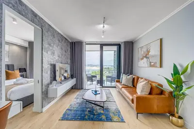 a living room with a couch and a bed at Lumina on 8th in Midrand