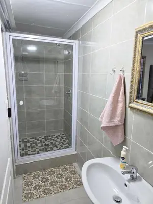 a bathroom with a shower and a sink at Peshline Guest House Unit 0 in Ermelo