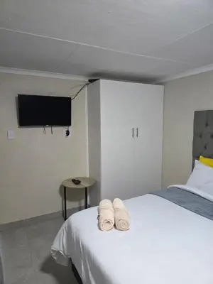 a bedroom with a bed with two towels on it at Peshline Guest House Unit 0 in Ermelo