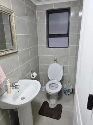 a bathroom with a white toilet and a sink at Peshline Guest House Unit 0 in Ermelo