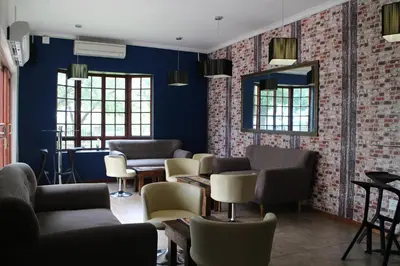 a waiting room with couches and chairs and a mirror at Cu Guest House in Phalaborwa