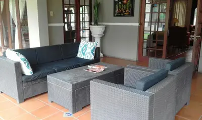 a living room with a blue couch and chairs at Cu Guest House in Phalaborwa