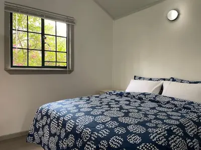 a bedroom with a blue and white bed with a window at Eindelik on Setlaars in Graskop