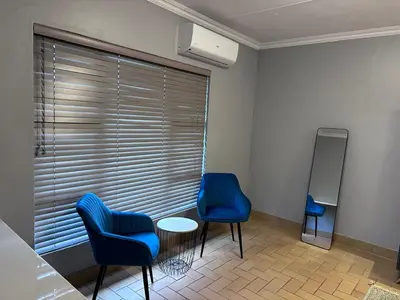 a room with two chairs and a table and a window at Forest and Ferns in Graskop