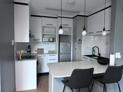 a kitchen with white cabinets and a table and chairs at Forest and Ferns in Graskop