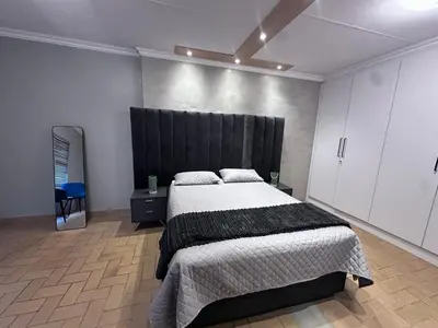 a bedroom with a large bed with a black headboard at Forest and Ferns in Graskop