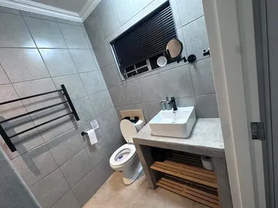 a bathroom with a sink and a toilet at Forest and Ferns in Graskop