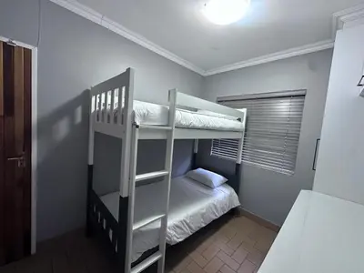 a bedroom with two bunk beds and a bed at Forest and Ferns in Graskop