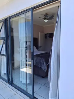 a room with sliding glass doors leading to a bedroom at The Blyde Couple Suite in Pretoria