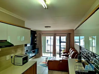 a living room with a couch and a tv at The Blyde Couple Suite in Pretoria