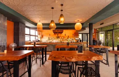 a restaurant with wooden tables and a bar at The Blyde Couple Suite in Pretoria