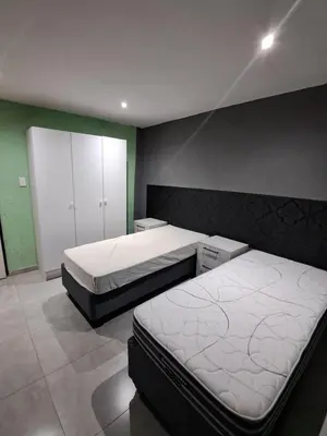 two beds in a room with green walls at Sibusisiwe 2 in Tasakani